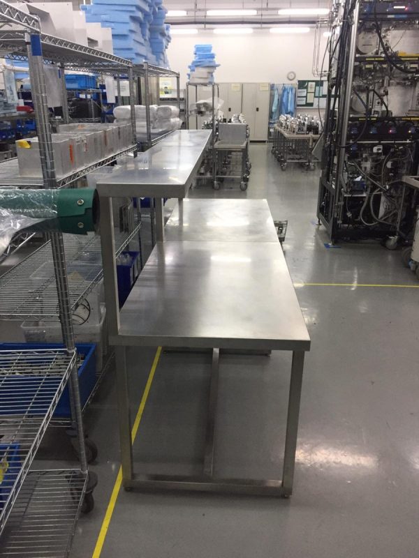Stainless Steel Production Bench with Overshelf – Singapore Long stainless steel production bench with overshelf riser in a Singapore cleanroom assembly area